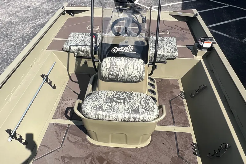 Slide: The Image of 2026 Tracker Grizzly 2072 CC boat interior with camouflage seating and steering console. - 5