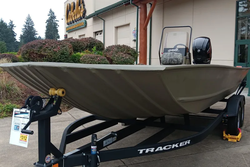 Slide: The Image of 2026 Tracker Grizzly 2072 CC boat on trailer outside Cabela's store. - 0