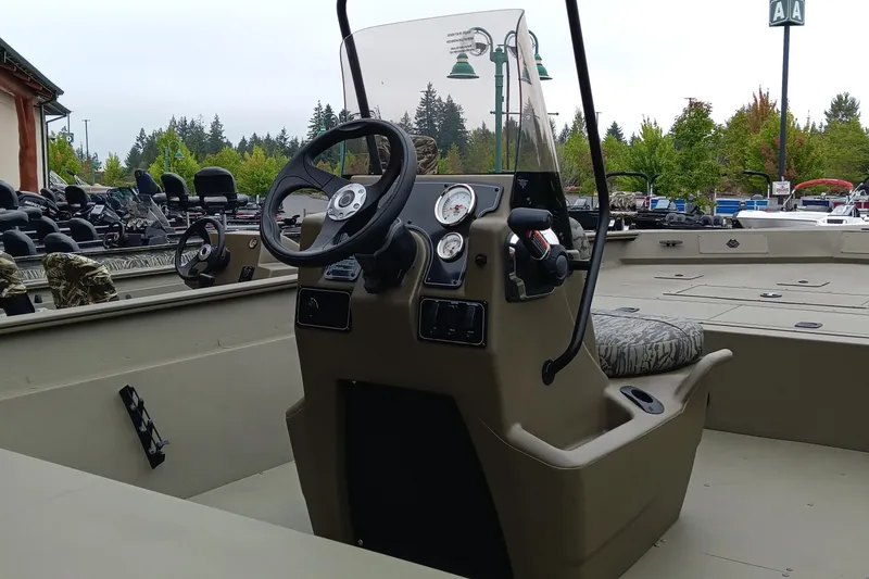 Slide: The Image of 2026 Tracker Grizzly 2072 CC boat interior with steering console and seating. - 3