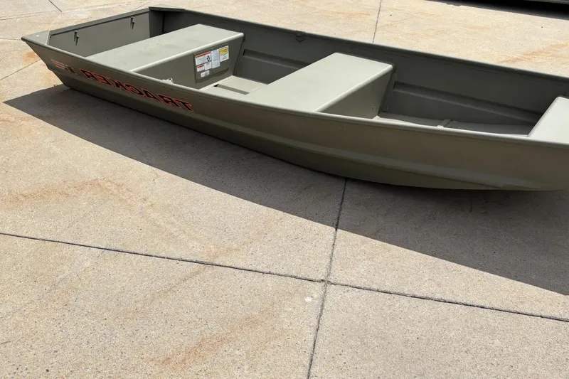 Slide: The Image of 2026 Tracker Grizzly 14 Jon boat on concrete surface, showcasing its sturdy design. - 55