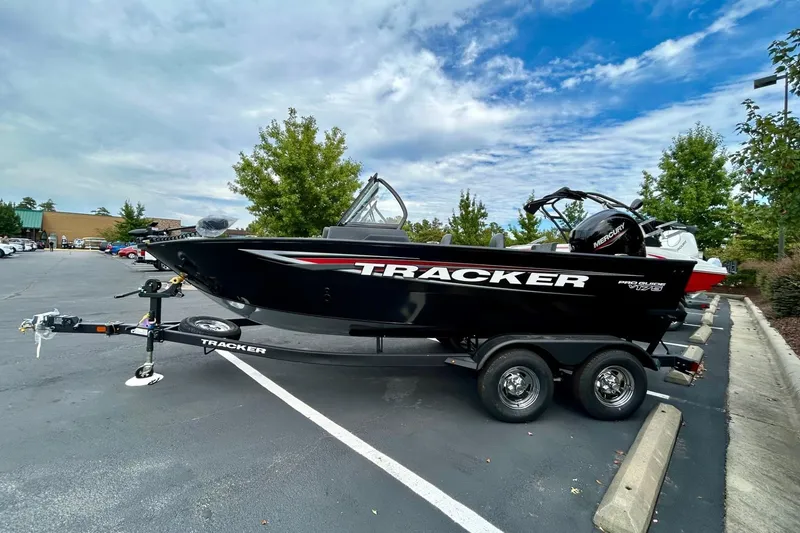 Slide: The Image of 2026 Tracker Pro Guide V-175 Combo boat on trailer in parking lot. - 2