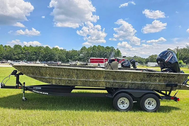 The Image of 2026 Tracker Grizzly 2072 CC boat on trailer, grassy field, blue sky background. - 1