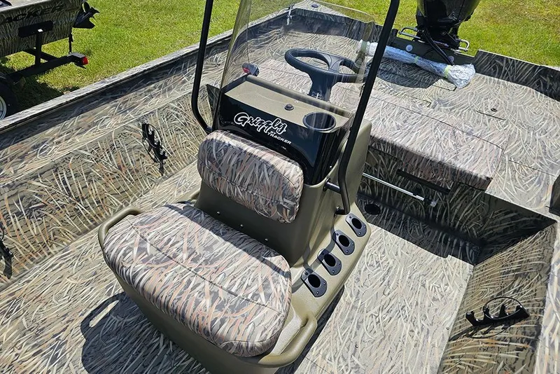 Slide: The Image of 2026 Tracker Grizzly 2072 CC boat interior with camo seats and steering console. - 10