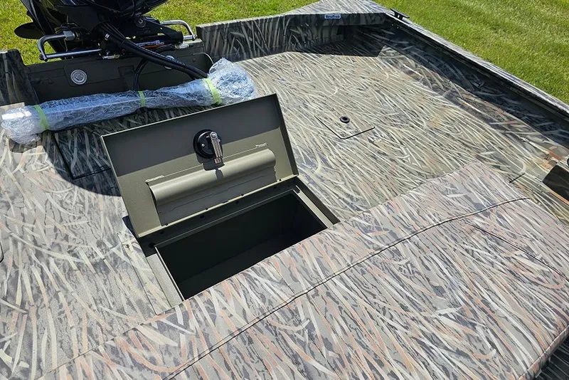 Slide: The Image of 2026 Tracker Grizzly 2072 CC boat with open storage compartment, camo design. - 9