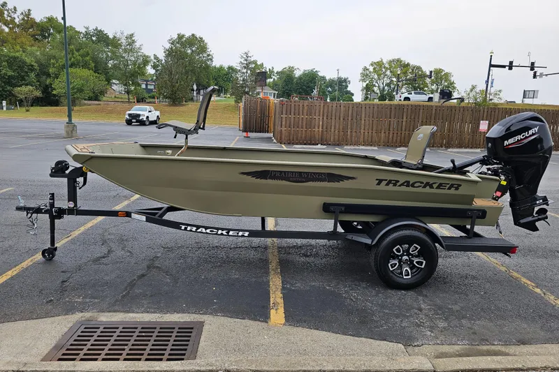 Slide: The Image of 2026 Tracker Grizzly 1650 T Prairie Wings Edition boat on trailer in parking lot. - 2
