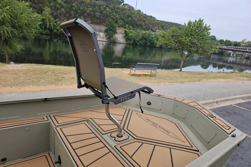Slide: The Image of 2026 Tracker Grizzly 1650 T Prairie Wings Edition boat by a scenic riverside. - 7