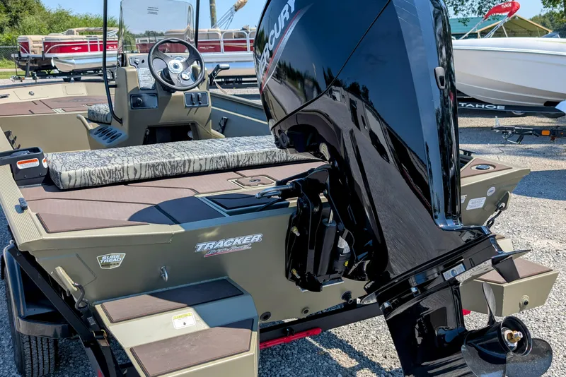 Slide: The Image of 2026 Tracker Grizzly 1860 CC boat with Mercury outboard motor, parked outdoors. - 3