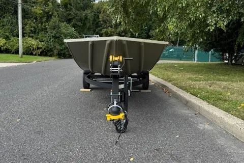 Slide: The Image of 2026 Tracker Grizzly 1648 Utility boat on trailer, parked on a suburban street. - 2