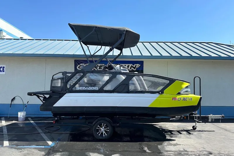 Slide: The Image of 2024 Sea-Doo Switch Sport 18 on trailer, parked outdoors, with canopy and vibrant design. - 1