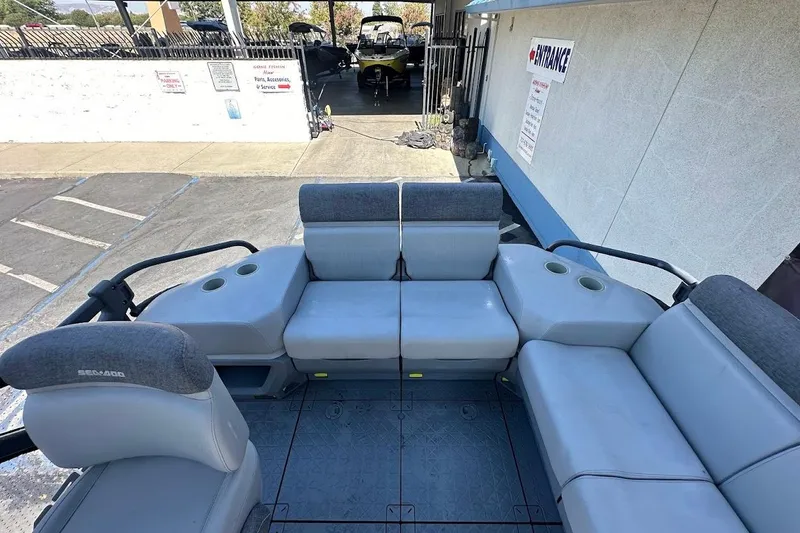 Slide: The Image of 2024 Sea-Doo Switch Sport 18 interior with gray seating and cup holders. - 13