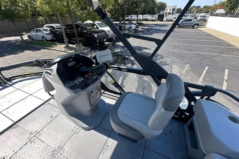 Slide: The Image of 2024 Sea-Doo Switch Sport 18 cockpit with steering and seating in a parking lot. - 15