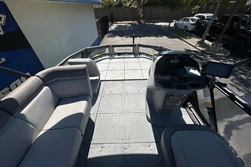 Slide: The Image of 2024 Sea-Doo Switch Sport 18 interior with seating and control console, parked outdoors. - 20