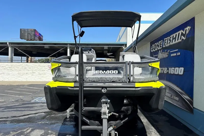 Slide: The Image of 2024 Sea-Doo Switch Sport 18 on trailer, parked outside dealership under clear blue sky. - 3