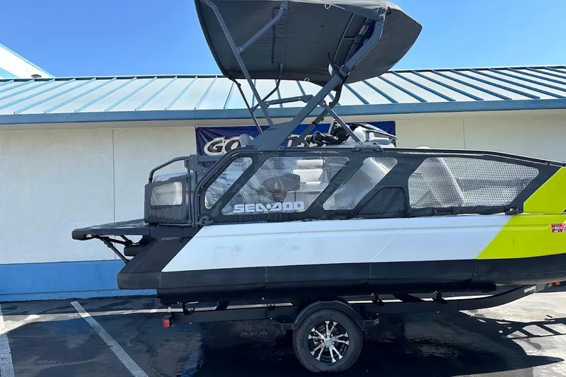 Slide: The Image of 2024 Sea-Doo Switch Sport 18 pontoon boat with canopy, parked outdoors. - 6