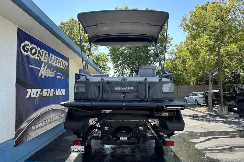 Slide: The Image of 2024 Sea-Doo Switch Sport 18 pontoon boat displayed outdoors at a dealership. - 8