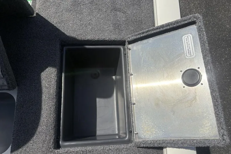Slide: The Image of Open storage compartment on 2026 Tracker Pro Team 190 TX boat, featuring carpeted interior. - 25