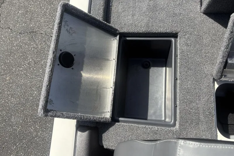 Slide: The Image of Open storage compartment in 2026 Tracker Pro Team 190 TX boat, featuring carpeted interior. - 28