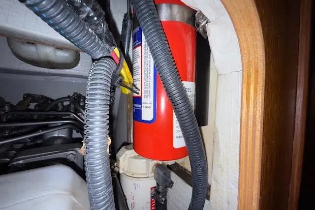 Slide: The Image of Fire extinguisher in 2005 Hunter 38 boat engine compartment with wiring and hoses. - 20