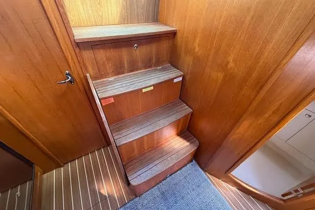 Slide: The Image of Wooden interior stairs on a 2005 Hunter 38 yacht, featuring a sleek design. - 23