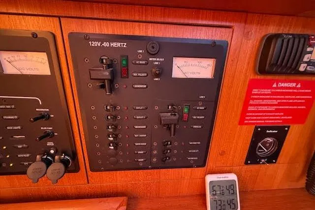 Slide: The Image of Electrical control panel on a 2005 Hunter 38 sailboat, featuring voltage meters and switches. - 26