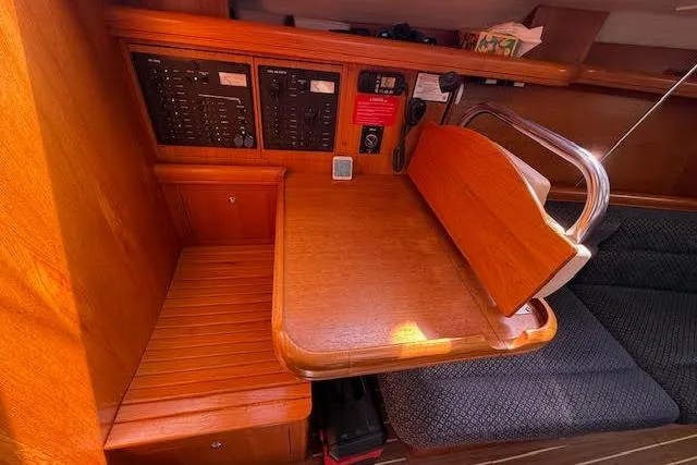 Slide: The Image of 2005 Hunter 38 yacht interior with wooden navigation station and control panels. - 29