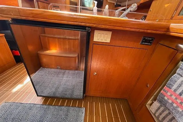 Slide: The Image of Interior of 2005 Hunter 38 yacht with wooden cabinetry and compact fridge. - 32