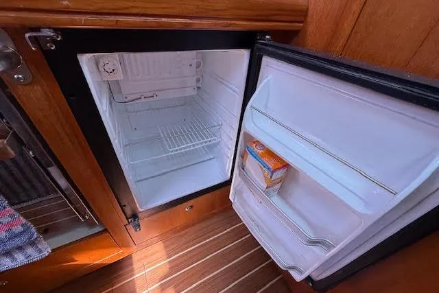 Slide: The Image of Open mini fridge on 2005 Hunter 38 yacht with wooden interior. - 35