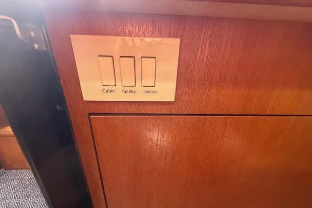 Slide: The Image of Light switches on a wooden panel in a 2005 Hunter 38 yacht interior. - 44