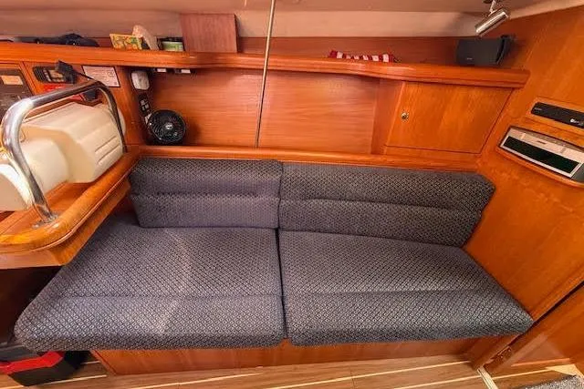 Slide: The Image of Interior of 2005 Hunter 38 sailboat with cushioned seating and wooden cabinetry. - 45