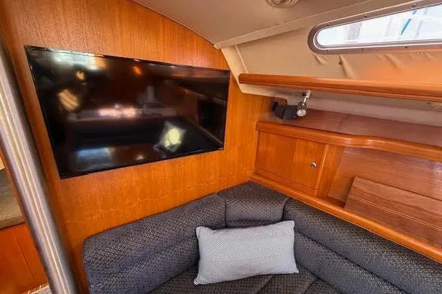 Slide: The Image of Interior of 2005 Hunter 38 yacht with TV, sofa, and wooden cabinetry. - 48