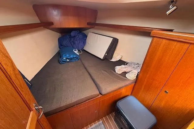 Slide: The Image of 2005 Hunter 38 sailboat cabin with wooden interior and cozy sleeping area. - 50