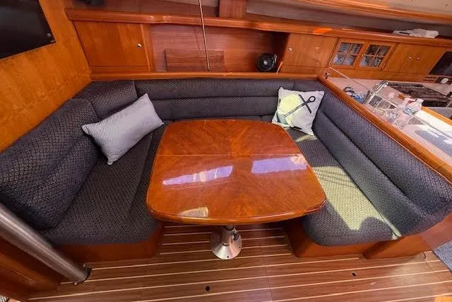Slide: The Image of Cozy interior of 2005 Hunter 38 sailboat with wooden table and cushioned seating. - 51