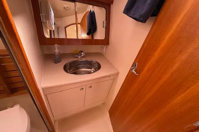 Slide: The Image of 2005 Hunter 38 yacht bathroom with sink, mirror, and wooden cabinetry. - 53