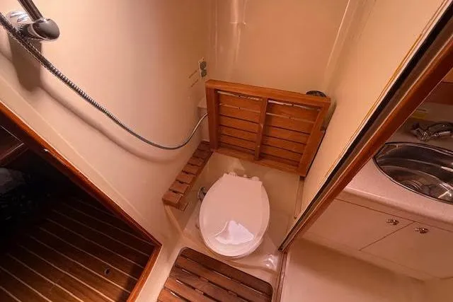 Slide: The Image of 2005 Hunter 38 yacht bathroom with shower, toilet, and wooden accents. - 54