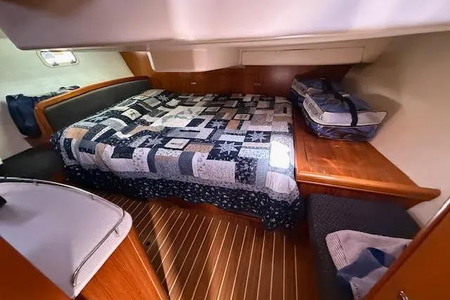 Slide: The Image of Cozy cabin interior of 2005 Hunter 38 sailboat with quilted bed and wooden accents. - 57