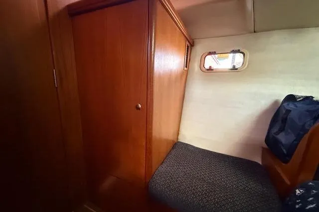 Slide: The Image of Cozy cabin interior of 2005 Hunter 38 sailboat with wooden paneling and small window. - 59