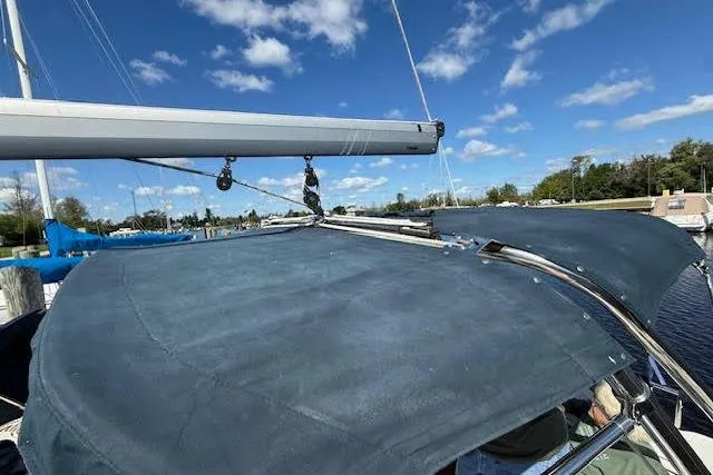 Slide: The Image of 2005 Hunter 38 sailboat with blue canvas cover and clear sky background. - 67