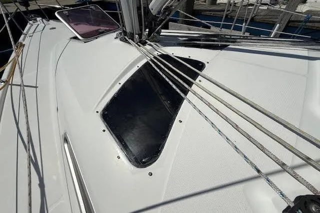 Slide: The Image of 2005 Hunter 38 sailboat deck with ropes and hatch, showcasing sleek design. - 68