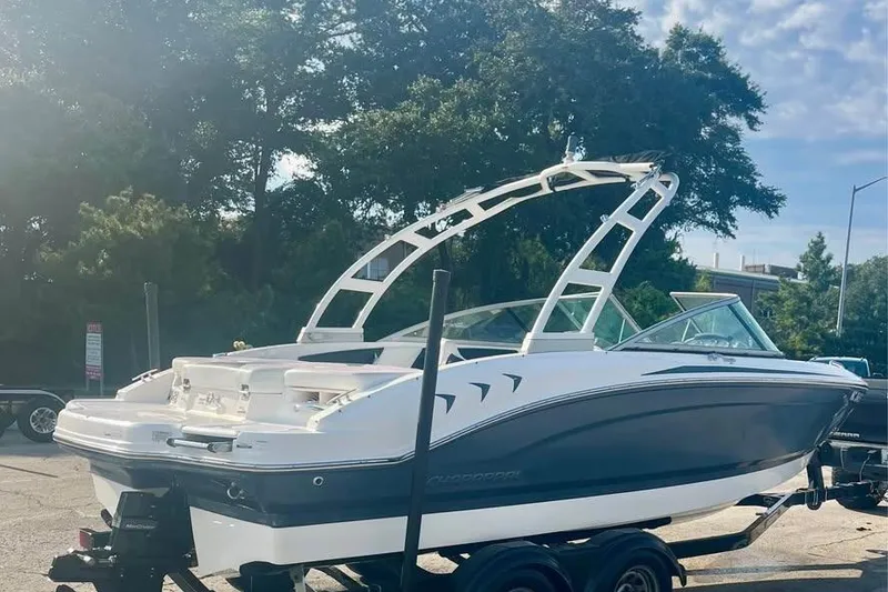 Slide: The Image of 2017 Chaparral 21 H2O Sport boat on trailer, parked outdoors under clear sky. - 14