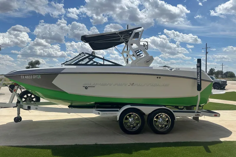 Slide: The Image of 2017 Nautique Super Air Nautique G21 boat on trailer under a bright blue sky. - 1