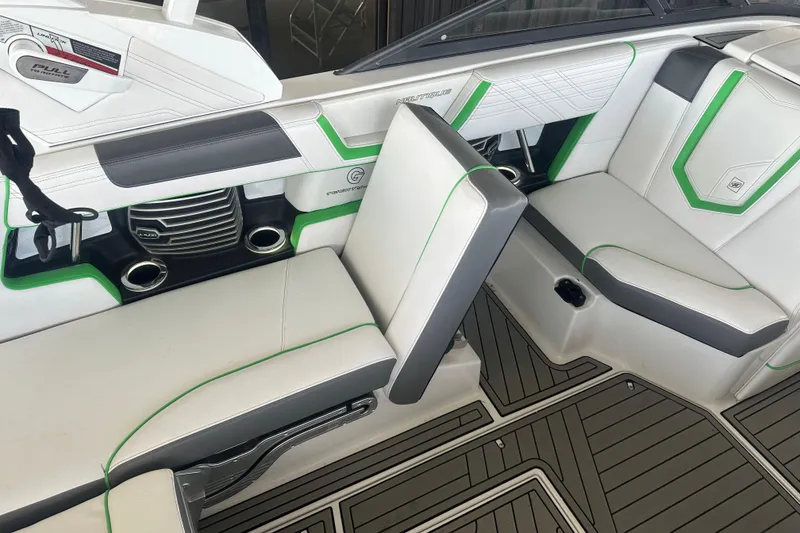 Slide: The Image of 2017 Nautique Super Air Nautique G21 interior with white and green seating, cup holders, and sleek design. - 12