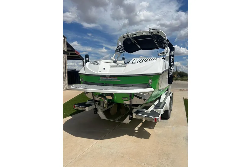 Slide: The Image of 2017 Nautique Super Air Nautique G21 boat, green and white, parked on a trailer. - 19