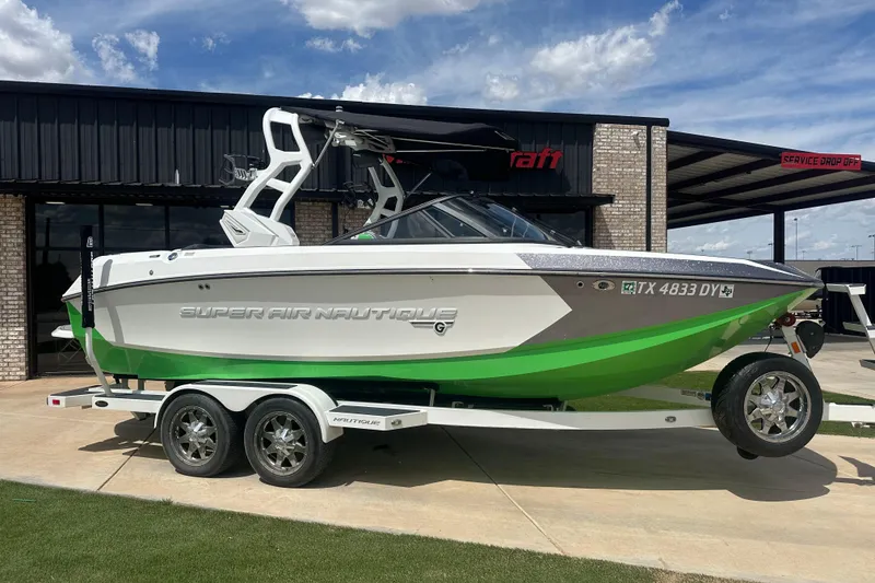 Slide: The Image of 2017 Nautique Super Air Nautique G21 boat on trailer, green and white design. - 2