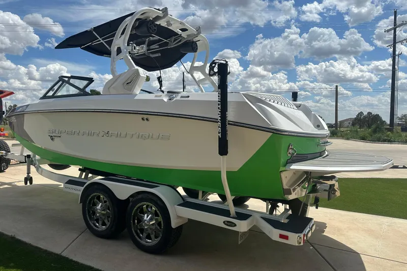 Slide: The Image of 2017 Nautique Super Air Nautique G21 boat on trailer, green and white design. - 21