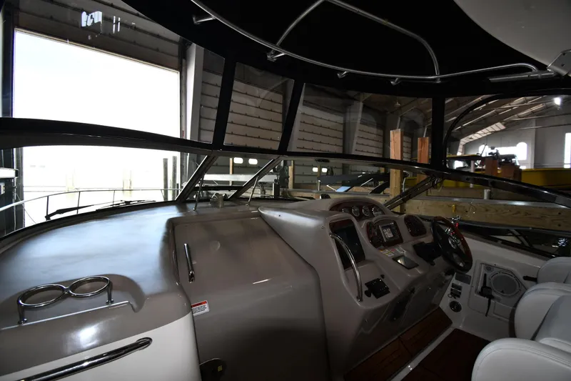 Slide: The Image of 2008 Sea Ray 340 Sundancer helm with modern controls and comfortable seating in a marina setting. - 11