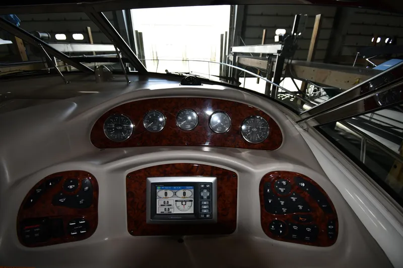 Slide: The Image of 2008 Sea Ray 340 Sundancer dashboard with gauges and control panel in a marina setting. - 16