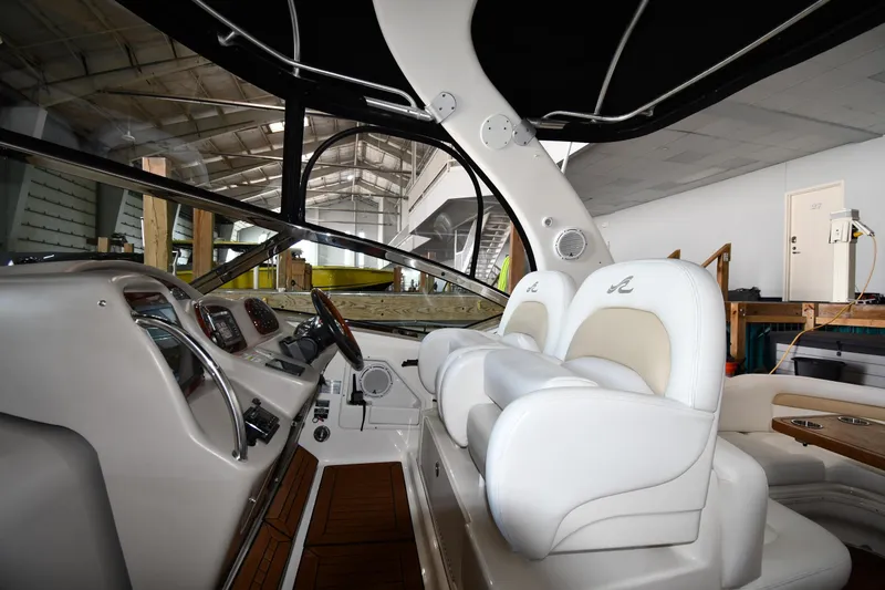 Slide: The Image of 2008 Sea Ray 340 Sundancer cockpit with white leather seats and modern dashboard controls. - 18
