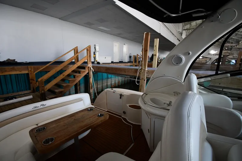 Slide: The Image of 2008 Sea Ray 340 Sundancer interior with wooden table and white seating in a marina setting. - 21