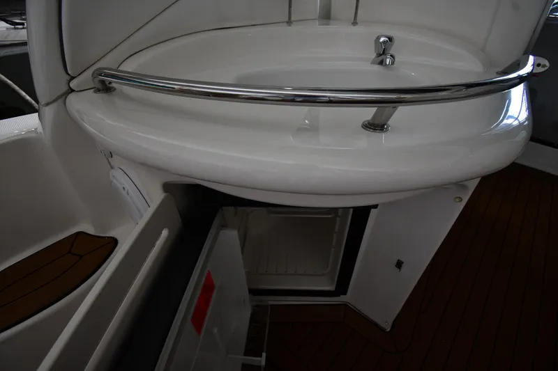 Slide: The Image of 2008 Sea Ray 340 Sundancer boat interior with sink and open mini fridge. - 24