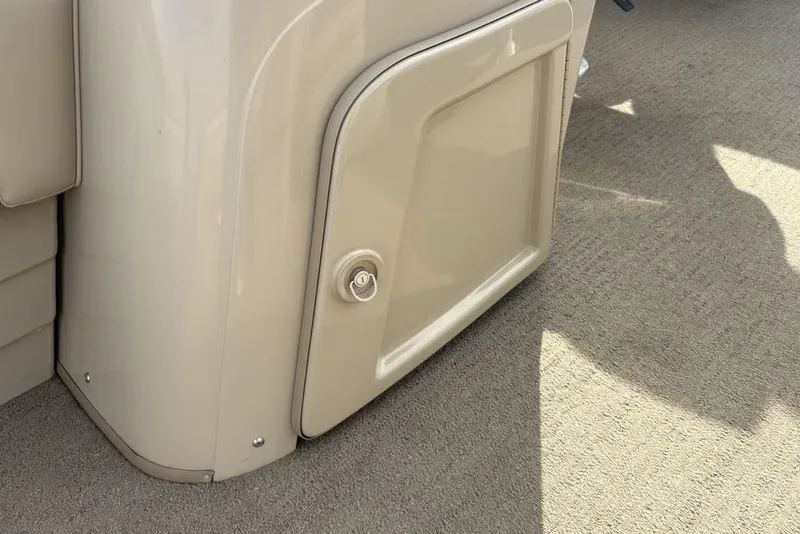 Slide: The Image of 2015 Bennington 24 SSRX boat storage compartment with beige finish and lock. - 17